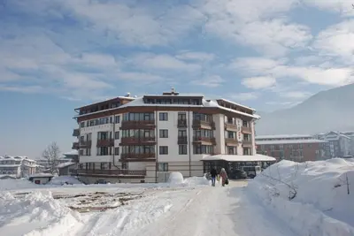 a building in the middle of a snow covered street at Elegant Lux Hotel in Bansko