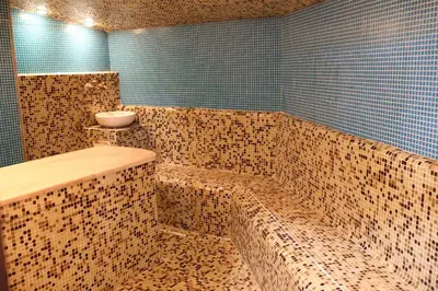 a tiled bathroom with a tub and a sink at Elegant Lux Hotel in Bansko