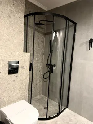 a glass shower in a bathroom with a toilet at Elegant Lux Hotel in Bansko