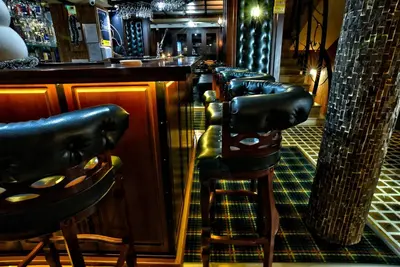 a row of leather bar stools at a bar at Hotel Friends in Bansko