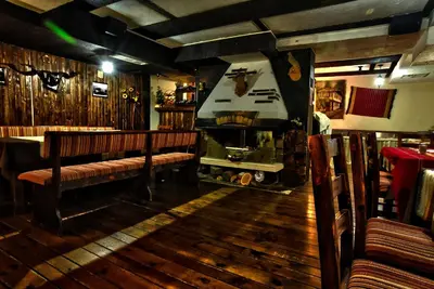 a restaurant with two benches and a boat on the wall at Hotel Friends in Bansko