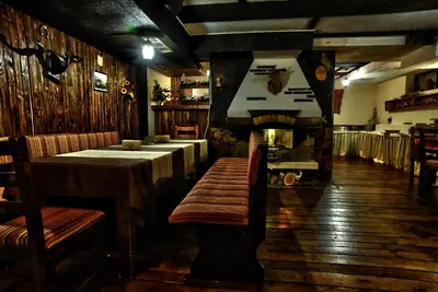 a restaurant with tables and a bench in a room at Hotel Friends in Bansko