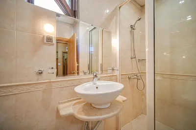 a bathroom with a white sink and a shower at Hotel Friends in Bansko