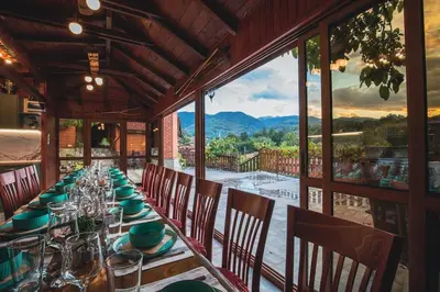 a dining room with a long table with chairs and a large window at Duvaro Guesthouse in Raduil