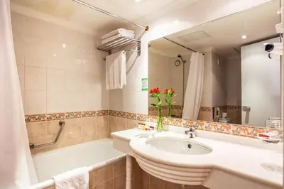 a bathroom with a sink and a bath tub at Ramada by Wyndham Sofia City Center in Sofia