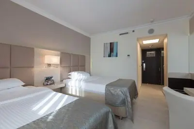 a hotel room with two beds and a chair at Ramada by Wyndham Sofia City Center in Sofia