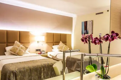 a hotel room with two beds and purple flowers at Ramada by Wyndham Sofia City Center in Sofia