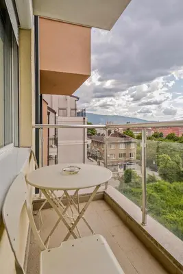a balcony with a table and chairs and a view at Vitosha View One Bedroom Apartment by Flat Mаnager in Sofia