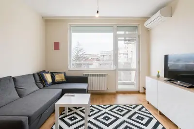 a living room with a couch and a tv at Vitosha View One Bedroom Apartment by Flat Mаnager in Sofia