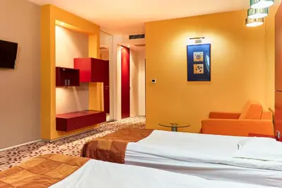 a hotel room with two beds and a couch at Monet Hotel in Plovdiv