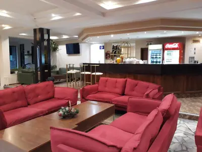 a lobby with red couches and a coffee table at Finlandia Hotel in Pamporovo