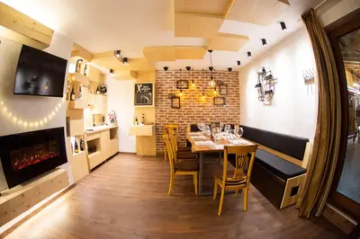 a dining room with a table and a brick wall at The Castle Complex in Pamporovo