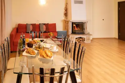 a dining room with a table with food and a fireplace at The Castle Complex in Pamporovo