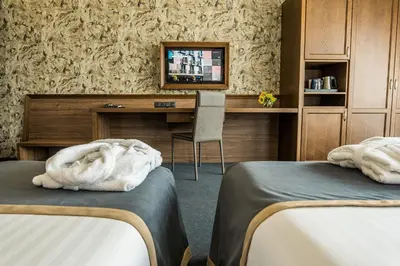 a hotel room with two beds and a desk at Budapest Hotel - Free Parking in Sofia