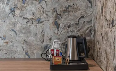 a coffee maker sitting on a counter next to a wall at Budapest Hotel - Free Parking in Sofia