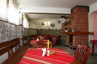a dining room with a table and a fireplace at Aseva House Guest house in Bansko