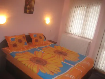 a bedroom with a bed with three sunflowers on it at Aseva House Guest house in Bansko
