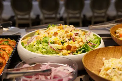 a table topped with two bowls of salad and other food at Vihren Royal Palace in Bansko