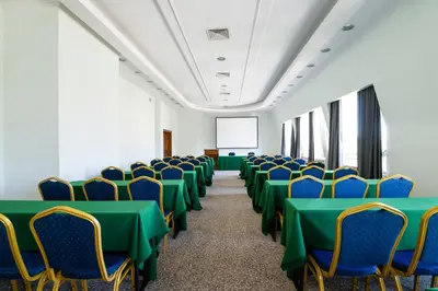 a conference room with green tables and chairs at Ramada by Wyndham Plovdiv Trimontium in Plovdiv