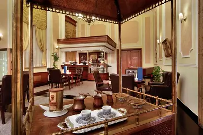 a living room with a table and a dining room at Ramada by Wyndham Plovdiv Trimontium in Plovdiv