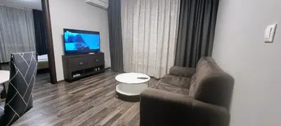 a living room with a couch and a television at Best Choice Apartment in Sofia