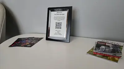 a sign on a table next to two books at Best Choice Apartment in Sofia