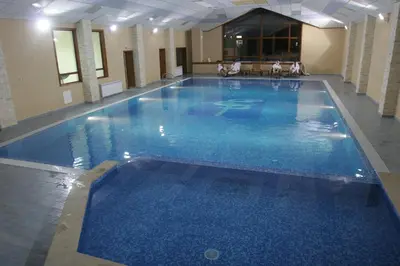 a large blue swimming pool in a building at Evelina Palace Hotel in Bansko