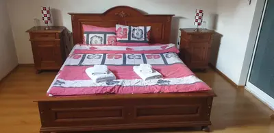 a bedroom with a large wooden bed with two night stands at Villa Filip in Bachevo