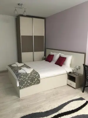 a bedroom with a large white bed with red pillows at Apartment Park Sveti Vrach in Sandanski