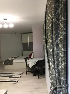a room with a bed and a table and a curtain at Apartment Park Sveti Vrach in Sandanski