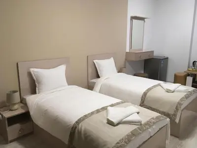 a bedroom with two beds with white sheets and a mirror at Apartment Park Sveti Vrach in Sandanski