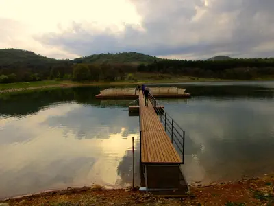 a bridge over a lake with two boats on it at Lavender Lodge in Rupkite