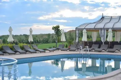 a pool at a resort with chairs and a gazebo at Lavender Lodge in Rupkite