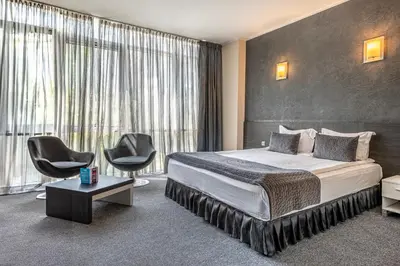 a hotel room with a bed and two chairs at Hotel Noris in Plovdiv