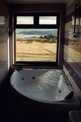 a bath tub in a room with a window at Vila Lidia in Tsigov Chark