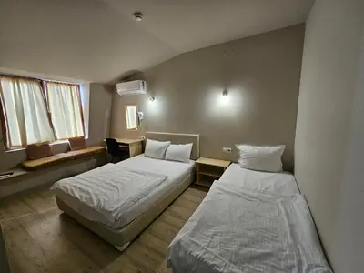 a hotel room with two beds and a couch at Hotel Racic Self-Check In in Voyvodinovo