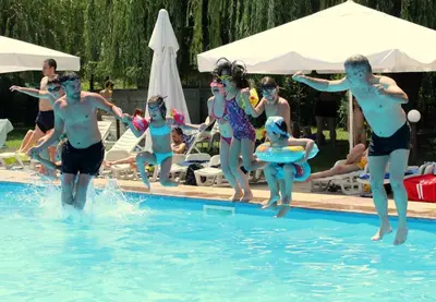 a group of people in the water at a swimming pool at Hotel Racic Self-Check In in Voyvodinovo