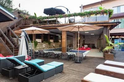 a patio with chairs and umbrellas on a building at Zarevata Guest House in Velingrad