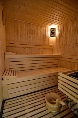 a sauna with a tub and a bucket in it at Zarevata Guest House in Velingrad