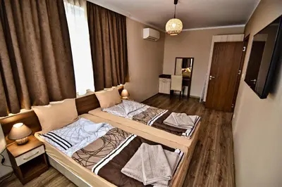 a bedroom with two beds in a room with a window at Zarevata Guest House in Velingrad