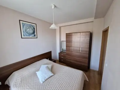 a bedroom with a bed and a wooden cabinet at Yastrebetz view in Borovets