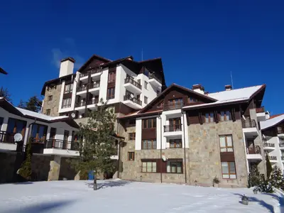 a large apartment building with snow on the ground at Yastrebetz view in Borovets