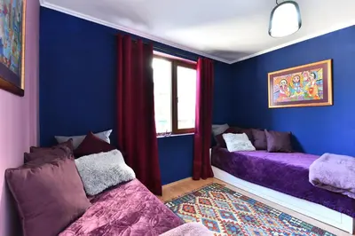 a blue room with two beds and a window at Gondola Flat Number 2 in Bansko