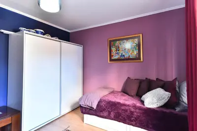 a bedroom with purple walls and a purple couch at Gondola Flat Number 2 in Bansko