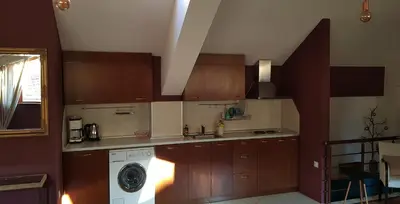 a kitchen with wooden cabinets and a washing machine at Studio Maison 3 Kapana in Plovdiv