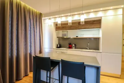 a kitchen with a table and chairs in a room at Lozenets Executive Apartment with Private Parking in Sofia