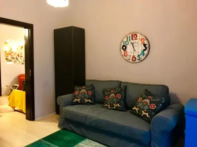 a living room with a couch and a clock on the wall at Han Krum 2 Bedroom Central Flat in Sofia
