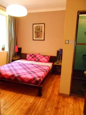 a bedroom with a bed and a wooden floor at Orient Express Guest House in Sofia