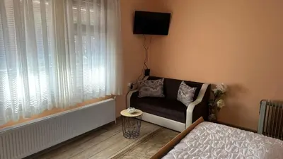 a living room with a couch and a tv on the wall at Villa Paradise in Beli Iskar