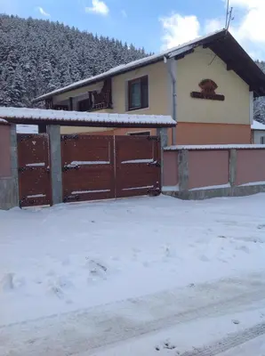 a house with two brown doors in the snow at Villa Paradise in Beli Iskar